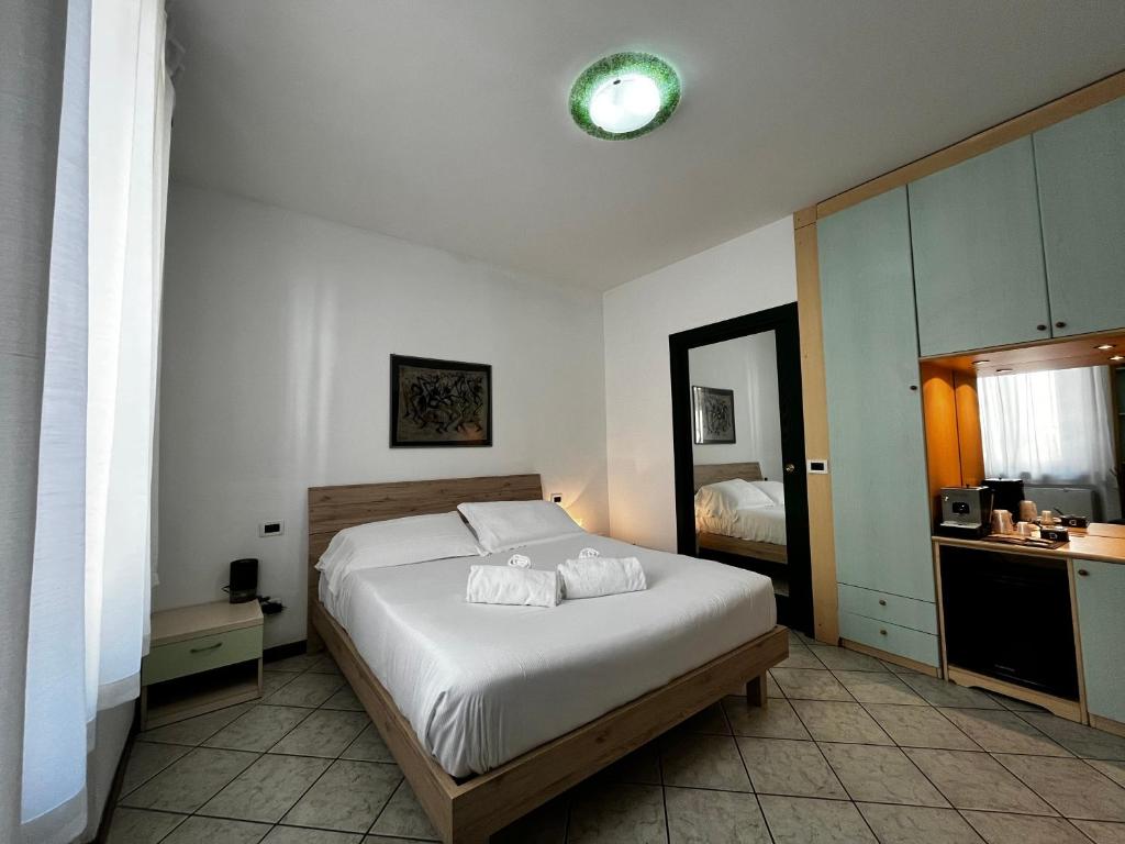 福洛尼卡Casa Carlotta的卧室配有白色的床和镜子