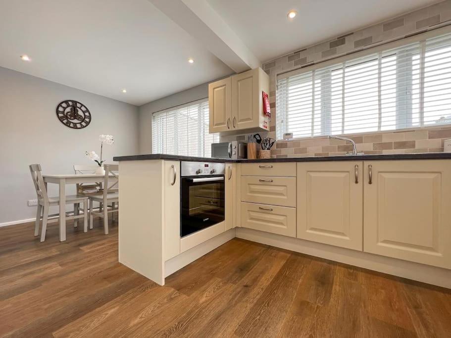 肯德尔'Benson View' - 2 bedroom Lake District home的一间大厨房,配有白色的橱柜和一张桌子