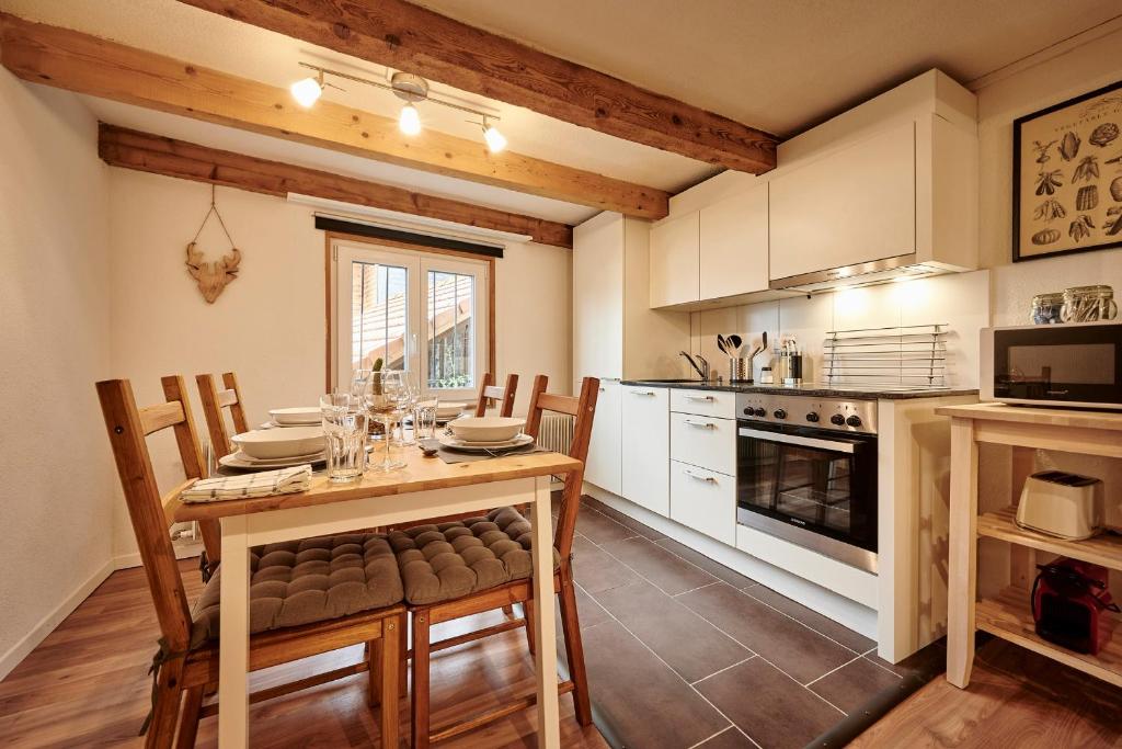 布里恩茨Lakeside Tiny House Brienz的厨房配有木桌、椅子和炉灶。