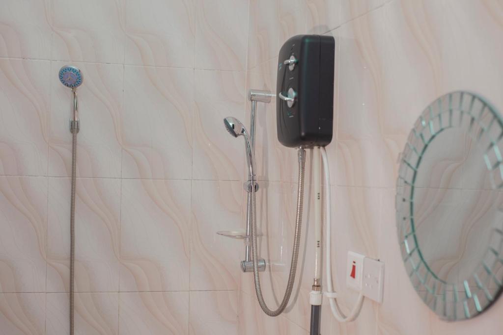 BantamaPATAYO LODGE的浴室设有淋浴,墙上配有电话