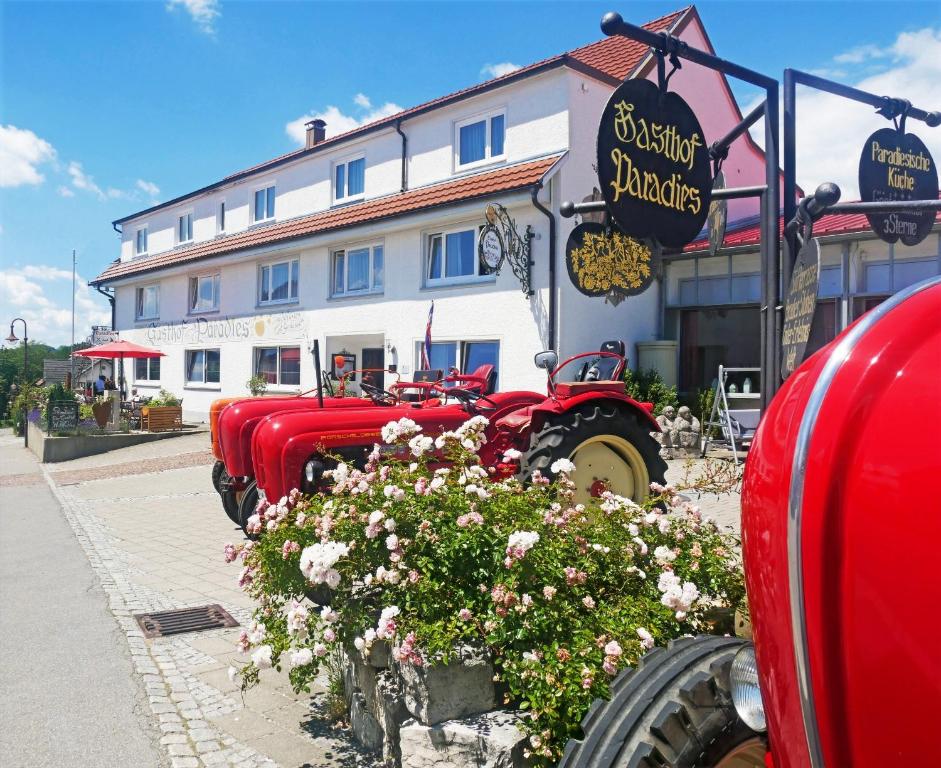 VogtAdam & Eva Gasthof Paradies mit Hotel的停在大楼前的一排红色卡车