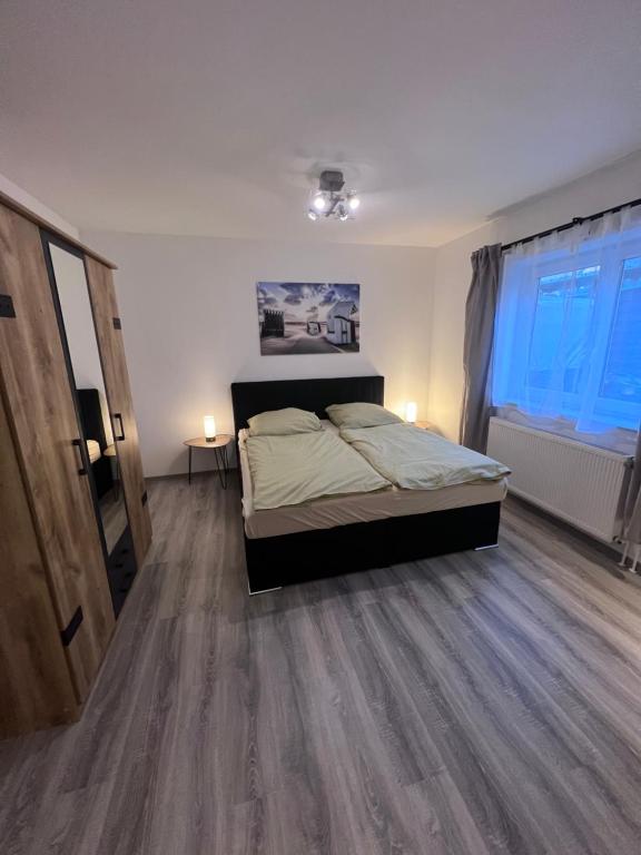 爱尔福特Schöne helle Ferienwohnung 64qm mit Kingsize Bett, Smart-TV, Wlan und sehr ruhige Lage的一间卧室配有一张床,铺有木地板