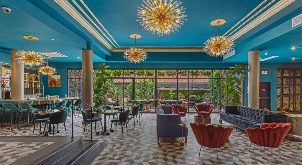 圣胡安Don Rafa Boutique Hotel & Residences的餐厅拥有蓝色的天花板和桌椅