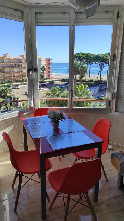 拉皮内达Promar的一张带红色椅子的餐桌,享有海景