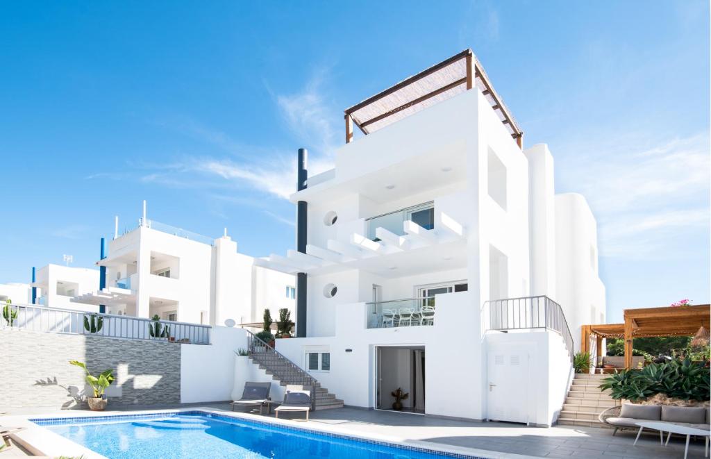 圣何塞德萨塔莱阿Villa Vidal的一座白色的房子,前面设有一个游泳池