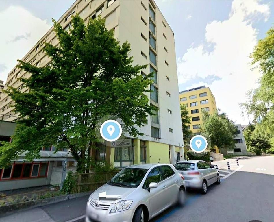 伯尔尼Apartment Zentrum Bern Marzili的两辆汽车停在大楼旁边的街道上