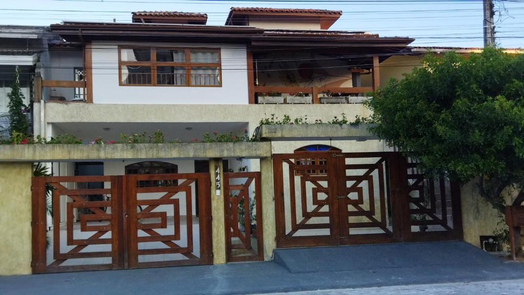 卡拉瓜塔图巴Pousada Primavera的前面有两扇木门的房子