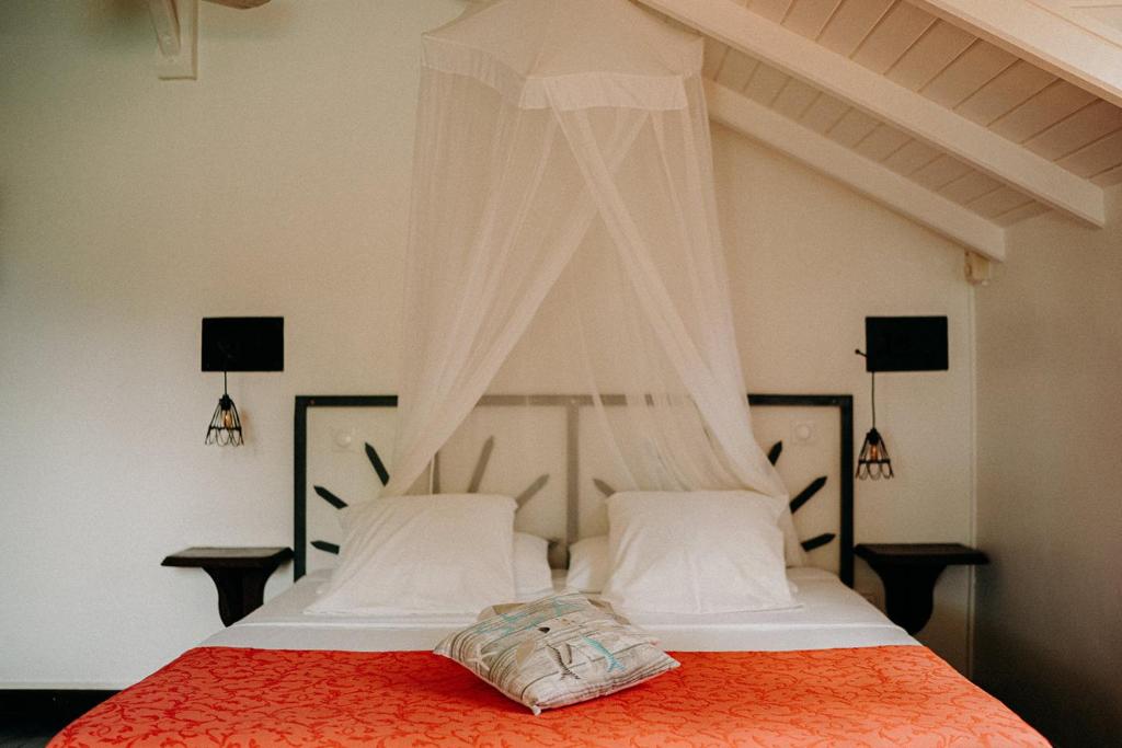 德赛Caraib'Bay Hotel的一间卧室配有一张红色棉被的床