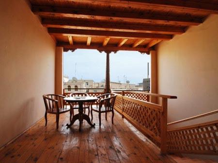希瓦Islambek Khiva的阳台的用餐室配有桌椅