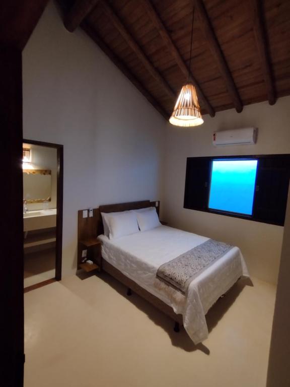 托兰克索Casa Harmonia, com 5 suítes em Trancoso-BA的一间卧室配有一张床和一台大电视