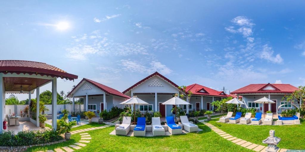 珍南海滩兰卡威尚提科酒店的草坪上带椅子和遮阳伞的度假村