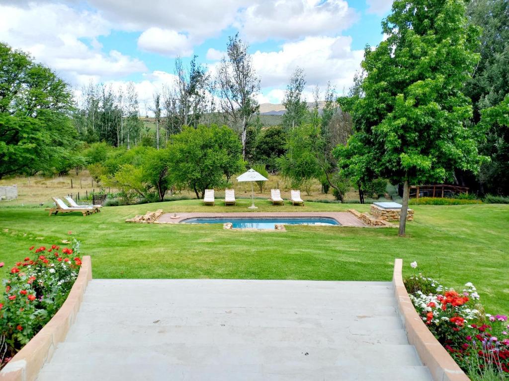 奥茨胡恩Aloe Valley Retreat的通往带游泳池的花园的步道