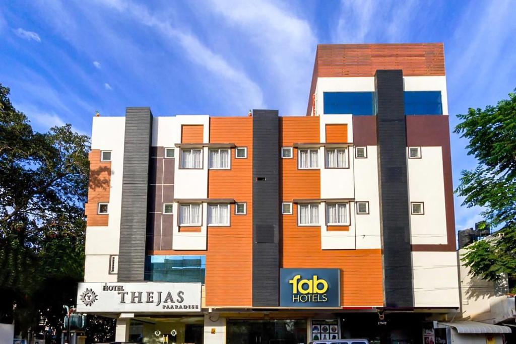 哥印拜陀FabHotel Thejas Paaradise Coimbatore International Airport的一座橙色和白色的建筑