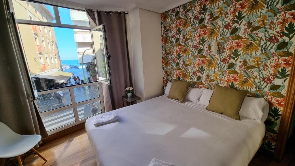 扎鲁亚斯伊巴尔膳食旅馆的配有大窗户的客房内的白色床