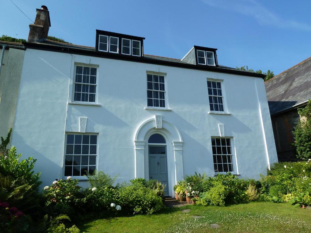 林顿Beautiful 6-Bed House in Lynton North Devon的白色的房子,有门和院子