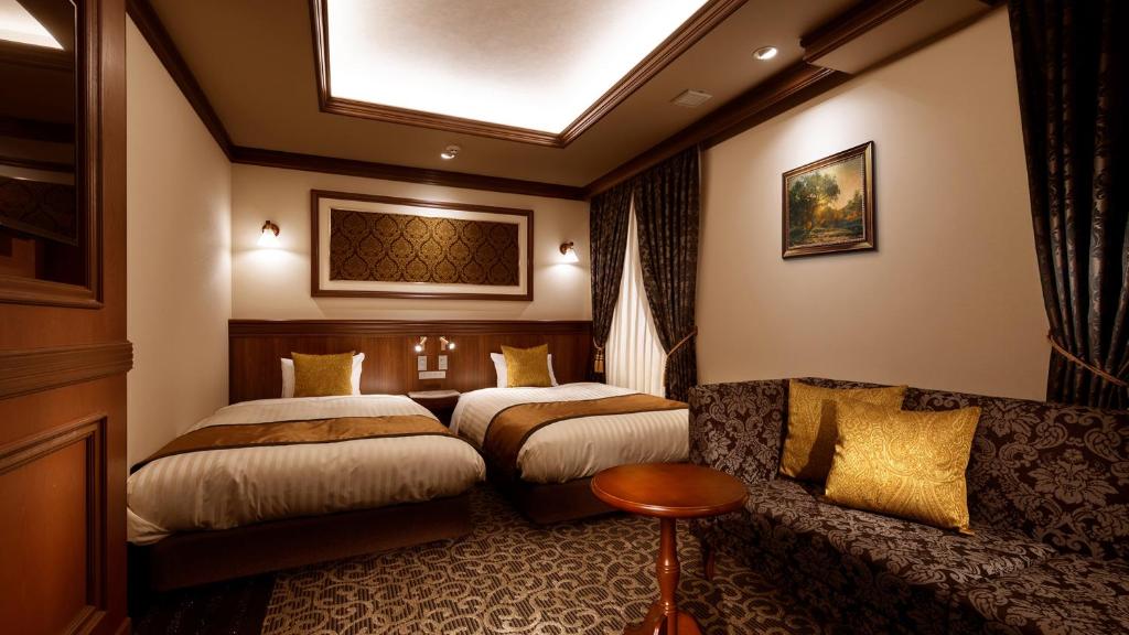 广岛Hiroshima Grand Intelligent Hotel的酒店客房,设有两张床和一张沙发