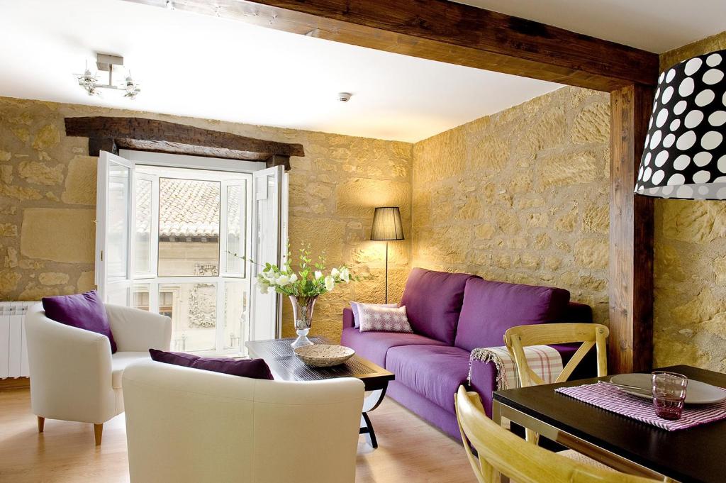 哈罗紫鞋旅游公寓的客厅配有紫色沙发和桌子