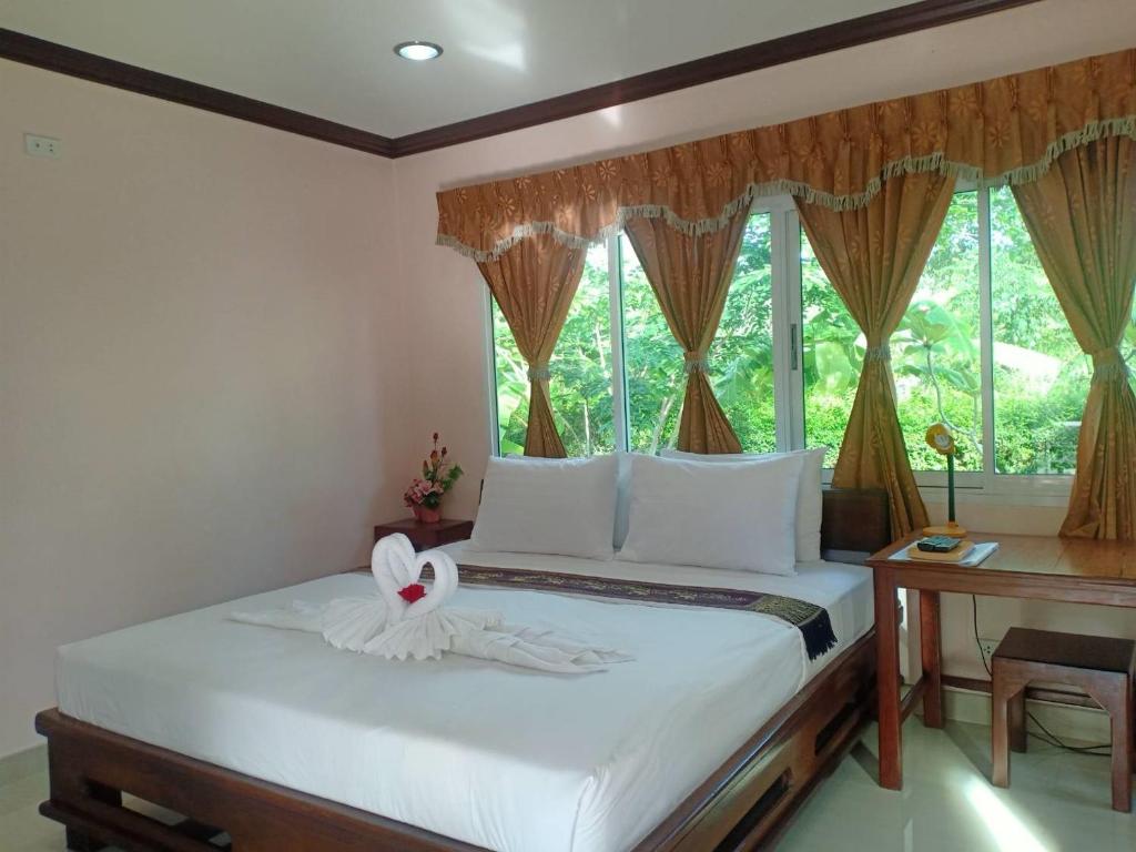 夜功府Capital O 75415 Nanthachart Riverview Resort的一间卧室配有一张带白色床单的床和一扇窗户。