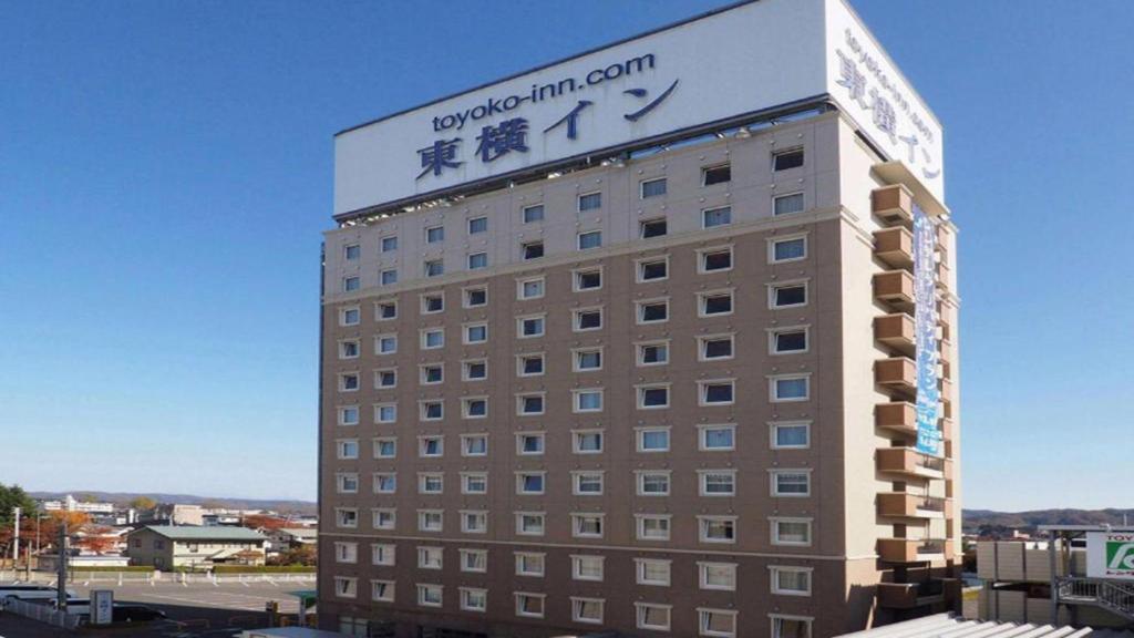 北上市Toyoko Inn Kitakami eki Shinkansen guchi的上面有标志的建筑