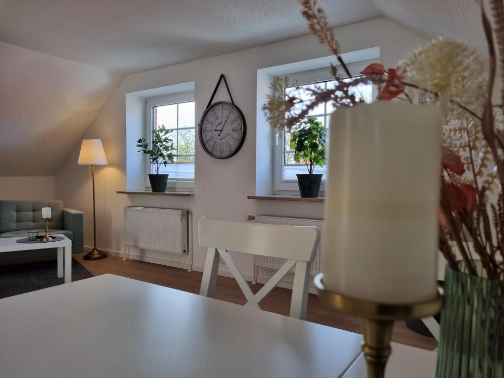 舍讷费尔德Ferienwohnung am Springerhof的客厅配有桌子和墙上的时钟