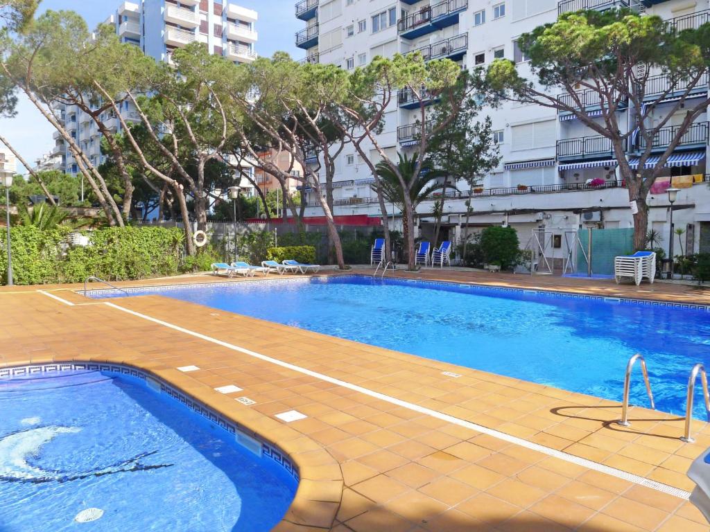 布拉内斯Apartment Santa Cruz by Interhome的一座有树木和建筑物的城市游泳池