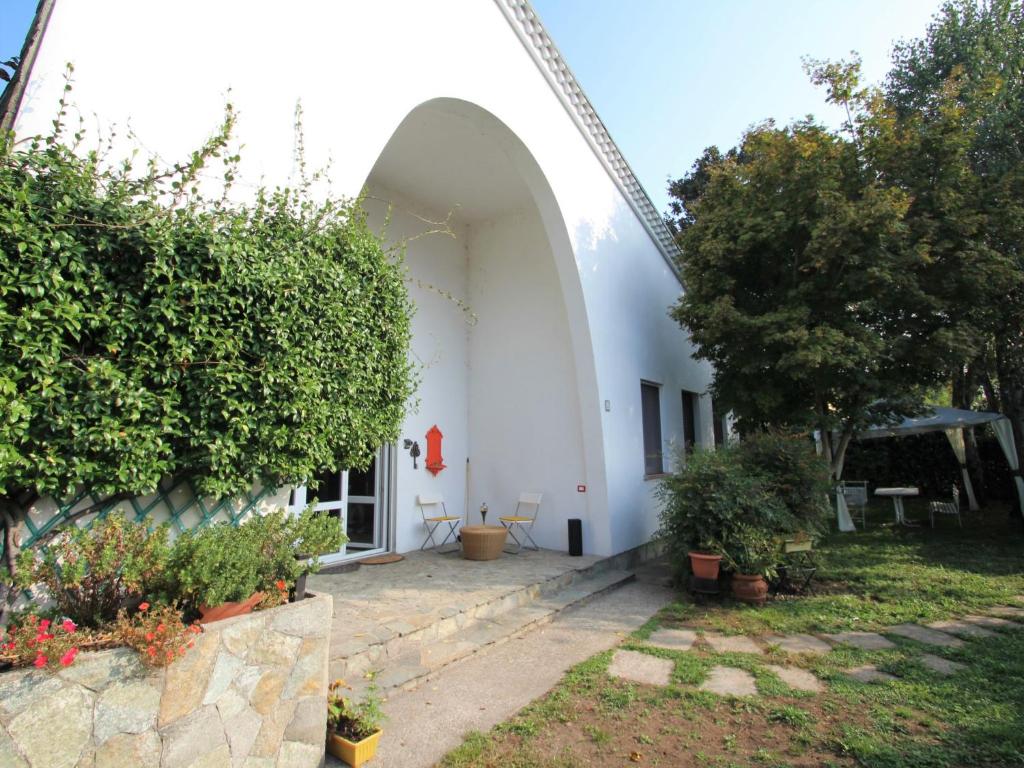 多尔梅莱托Holiday Home Bruna by Interhome的一座白色的建筑,有拱门和一些植物