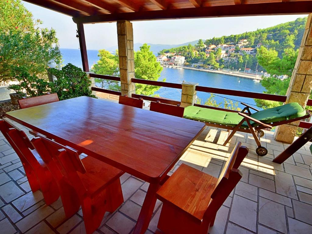 普利格拉迪卡Holiday Home Peter by Interhome的阳台上配有一张木桌和椅子,享有水景