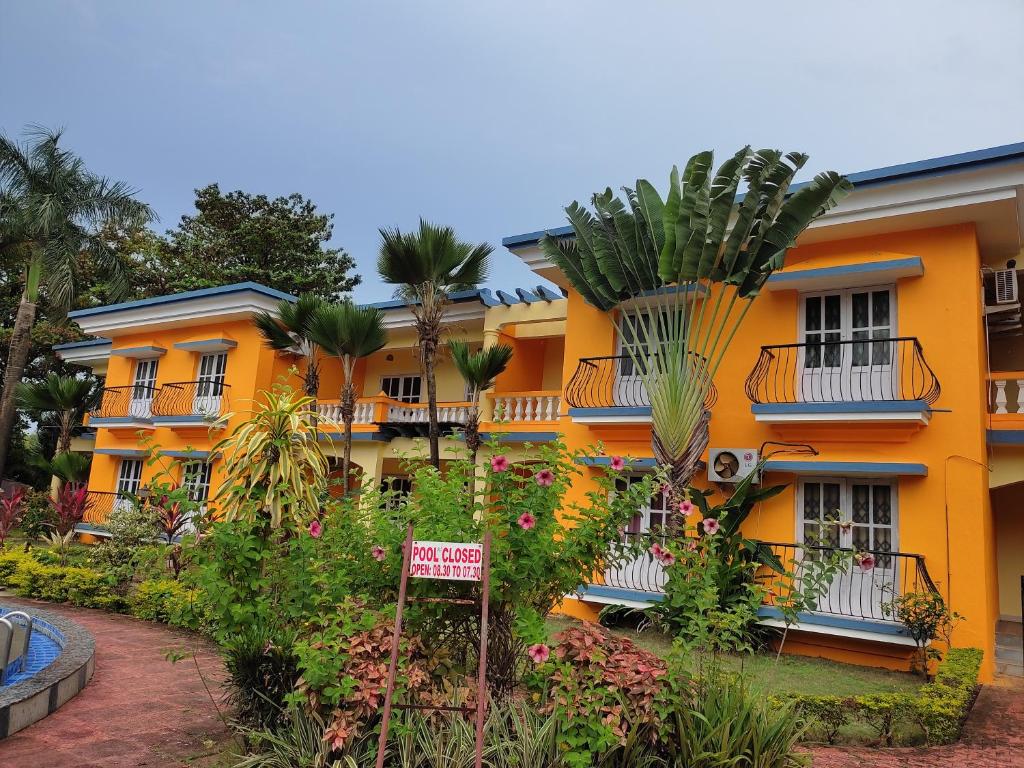 科尔瓦Beach Apartment 2,COLVA , GOA, INDIA的一座橙色的建筑,前面有标志