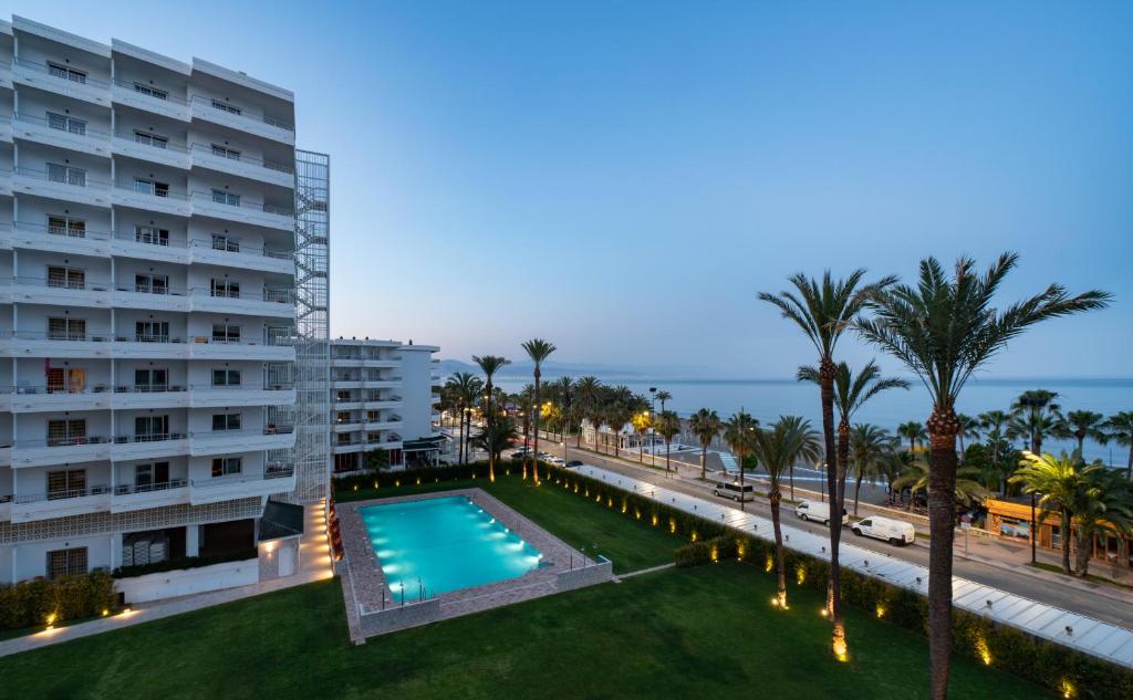 多列毛利诺斯Hotel Apartamentos Bajondillo的享有带游泳池和棕榈树的建筑的空中景致