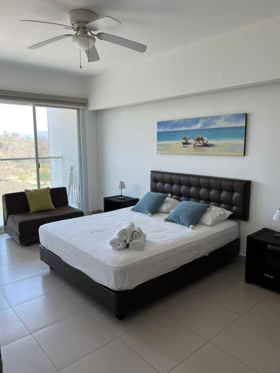通苏帕Resort Playa Azul Departamentos frente al mar的一间卧室配有一张大床和一张沙发