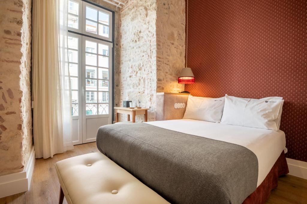 里斯本Boemio FLH Hotels的一间卧室设有一张大床和一个窗户。
