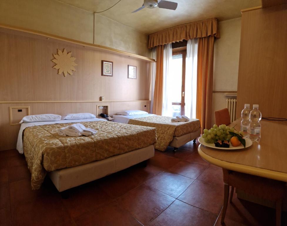 博尔特伊略Hotel San Giorgio的酒店客房设有两张床和一张桌子。