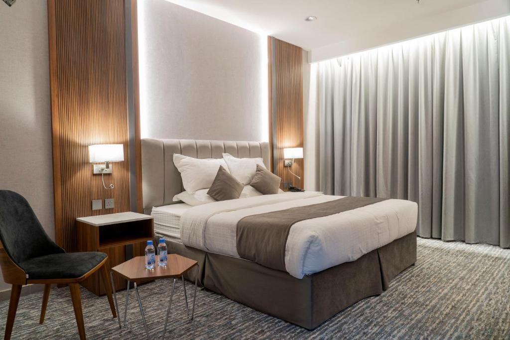 Sīdī Ḩamzahفندق ركاز الماسي - Rekaz Diamond Hotel的配有一张床和一把椅子的酒店客房