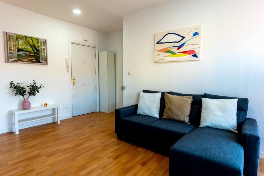 马德里Homely 2 Bedroom Apartment in Barajas的客厅配有蓝色的沙发和桌子