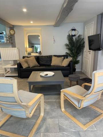 勒特雷波尔La Maison Bleue, proche de tout的客厅配有两把椅子和一张沙发