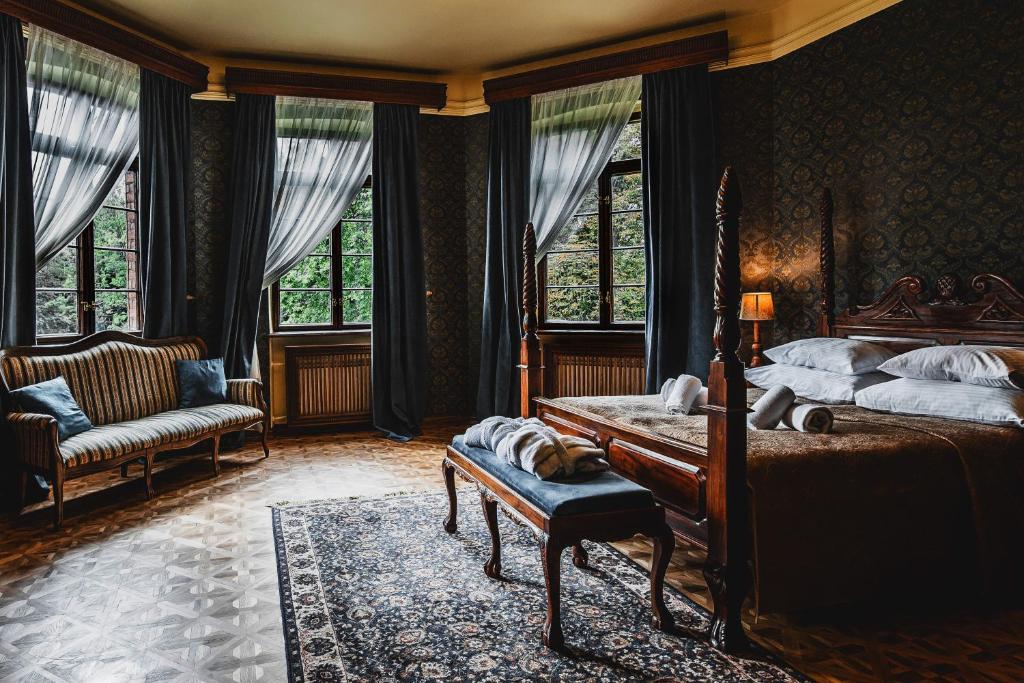 鲁策沃Zamek Rzucewo的一间卧室配有一张床、一张沙发和窗户。