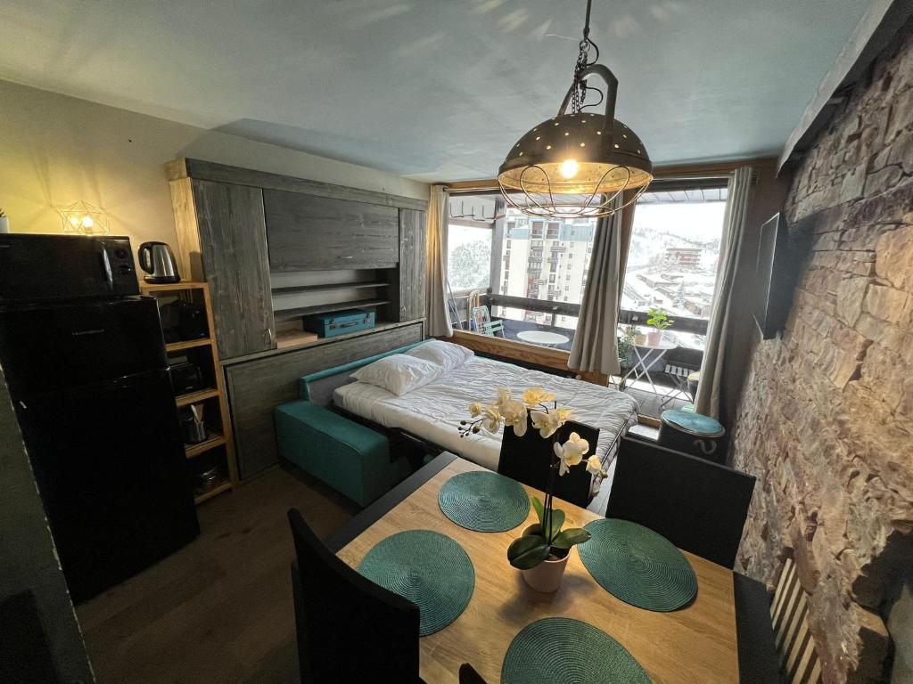 蒂涅Appt 123 Home Club Tignes的一间带桌子和床的房间以及一间卧室