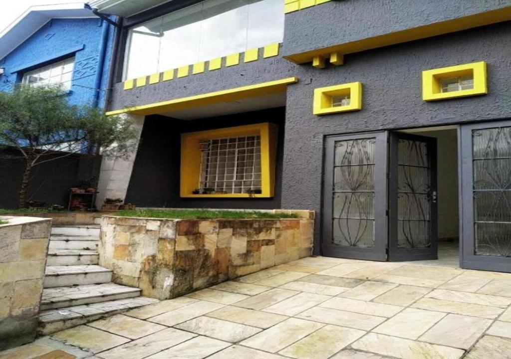 库里提巴Gup Hostel的一座带黄色窗户和门的房子