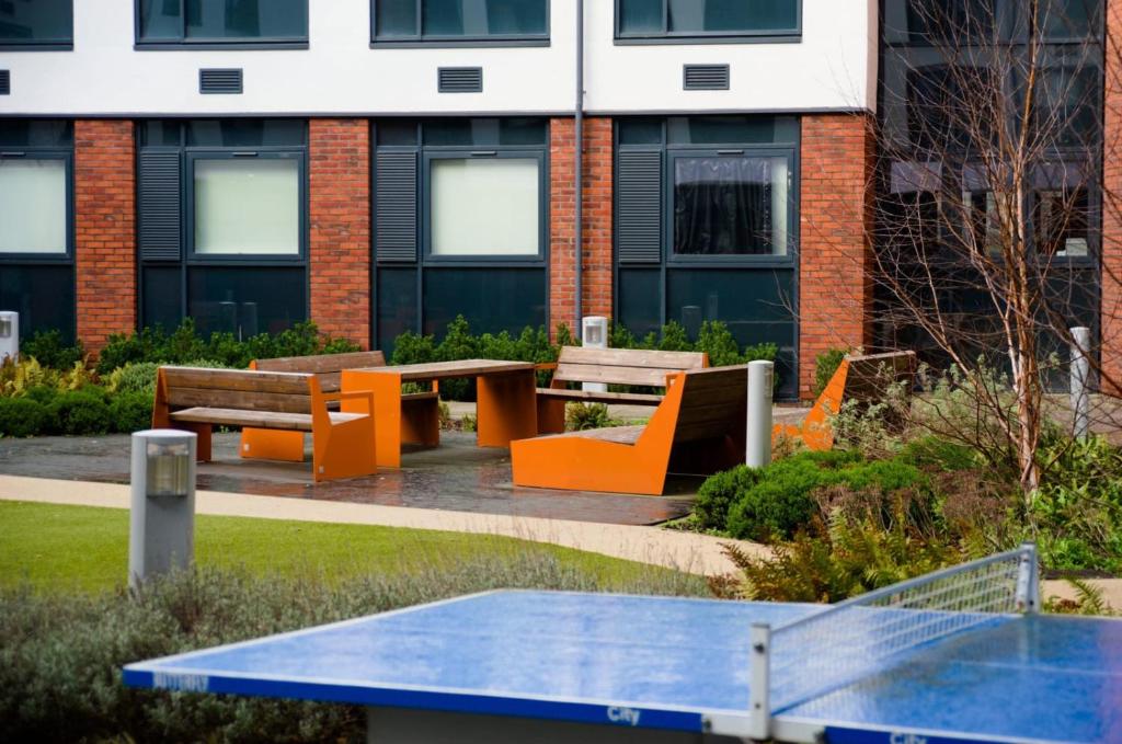 卡迪夫For Students Only - Premium Accommodation at Eclipse Student Accommodation in Cardiff的大楼前的野餐桌和长凳