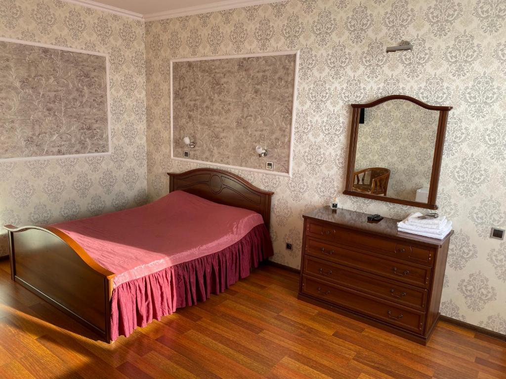 PodgortsyAquarius的一间卧室配有一张床、梳妆台和镜子