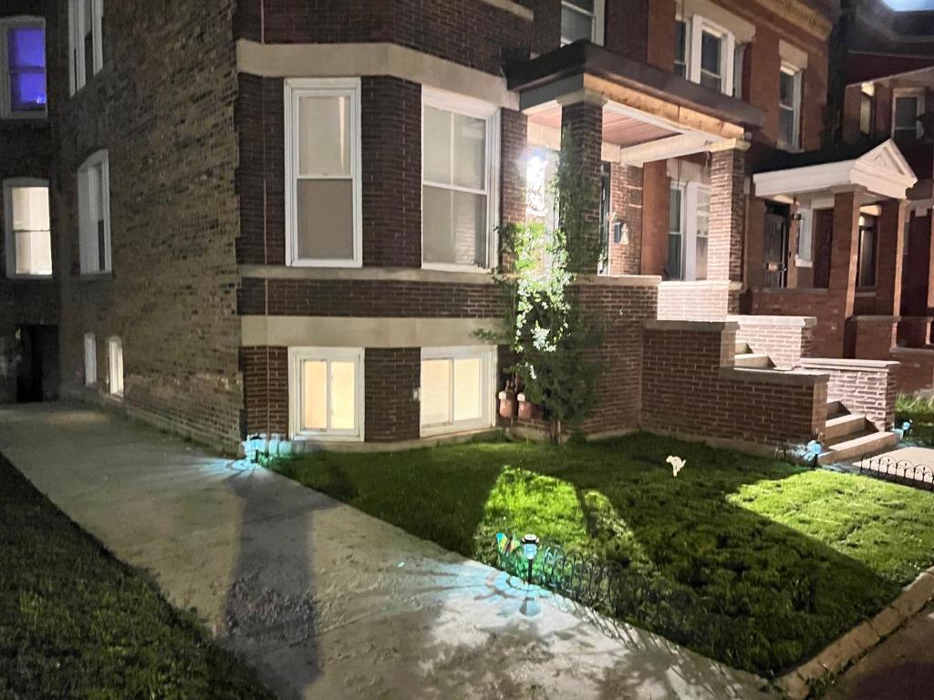 芝加哥Simplified Living Space的夜间砖屋,有绿色草坪