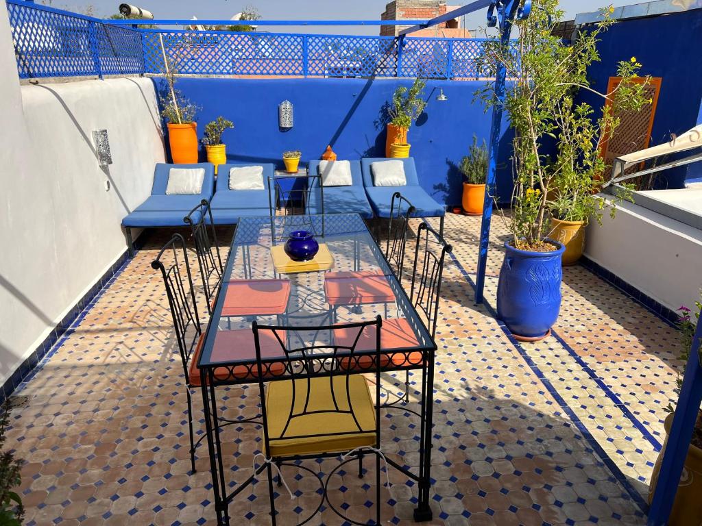 马拉喀什埃尔阿萨别墅酒店的植物阳台的桌椅