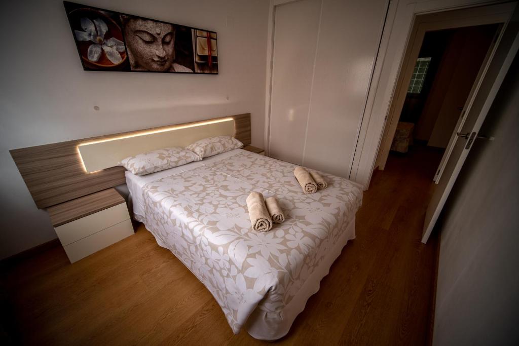 阿利坎特Orillas del Castillo的一间小卧室,配有带毛巾的床