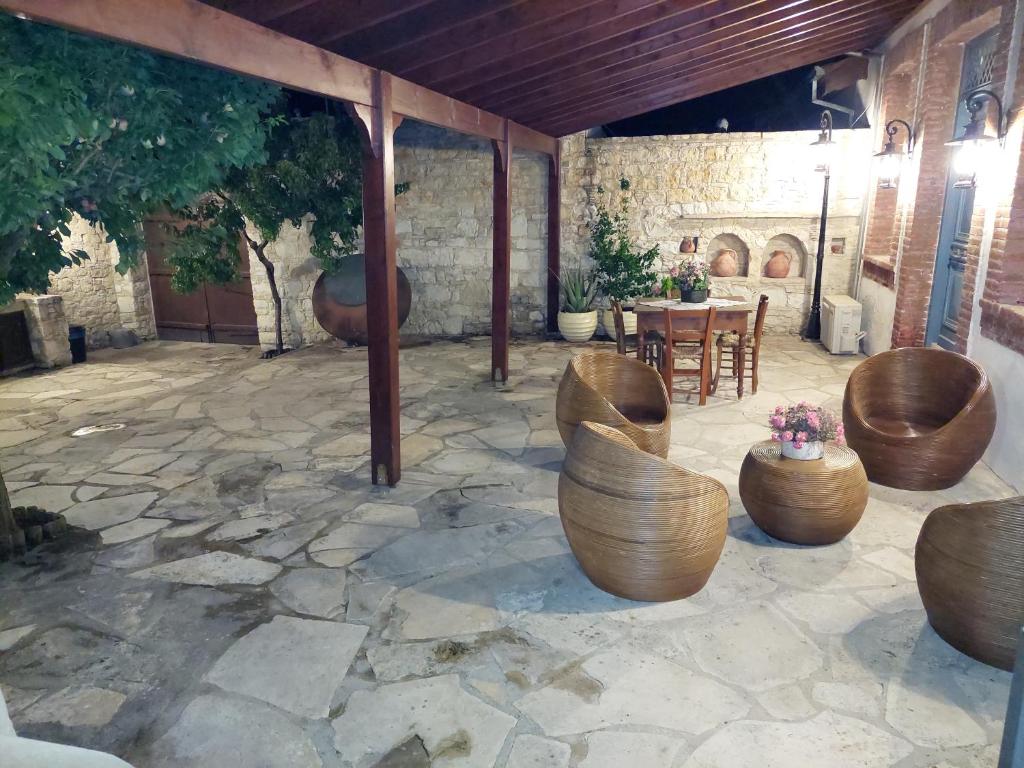 KoilaniEvanthia's Stone House的庭院设有木椅、桌子和石材地板。