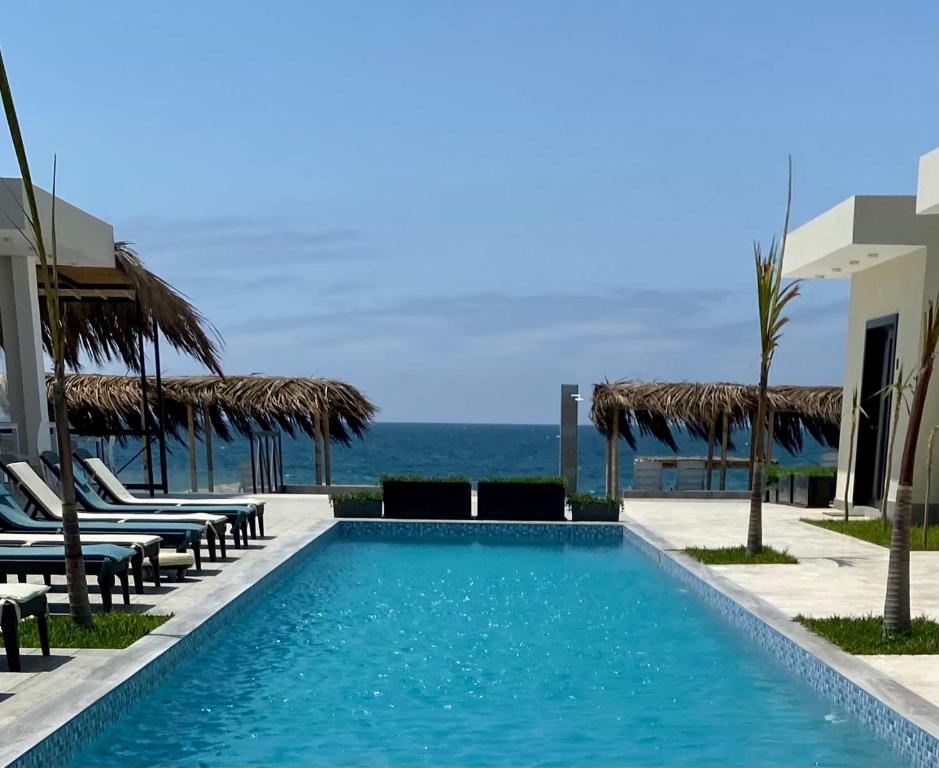 维加伊托Riviera Vichayito的一个带椅子的游泳池,背景是大海