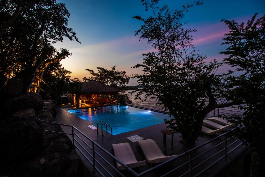 阿鲁甘湾Oruwa Boutique Villas的一个带躺椅的游泳池,享有日落美景