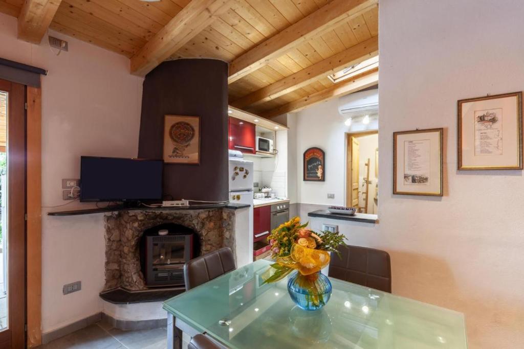 蒙特马塞洛Chicca blu的厨房设有壁炉和带花瓶的桌子。