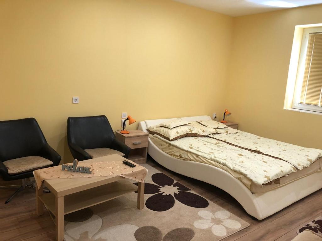 博加奇Relax Bogács的一间卧室配有一张床、两把椅子和一张桌子