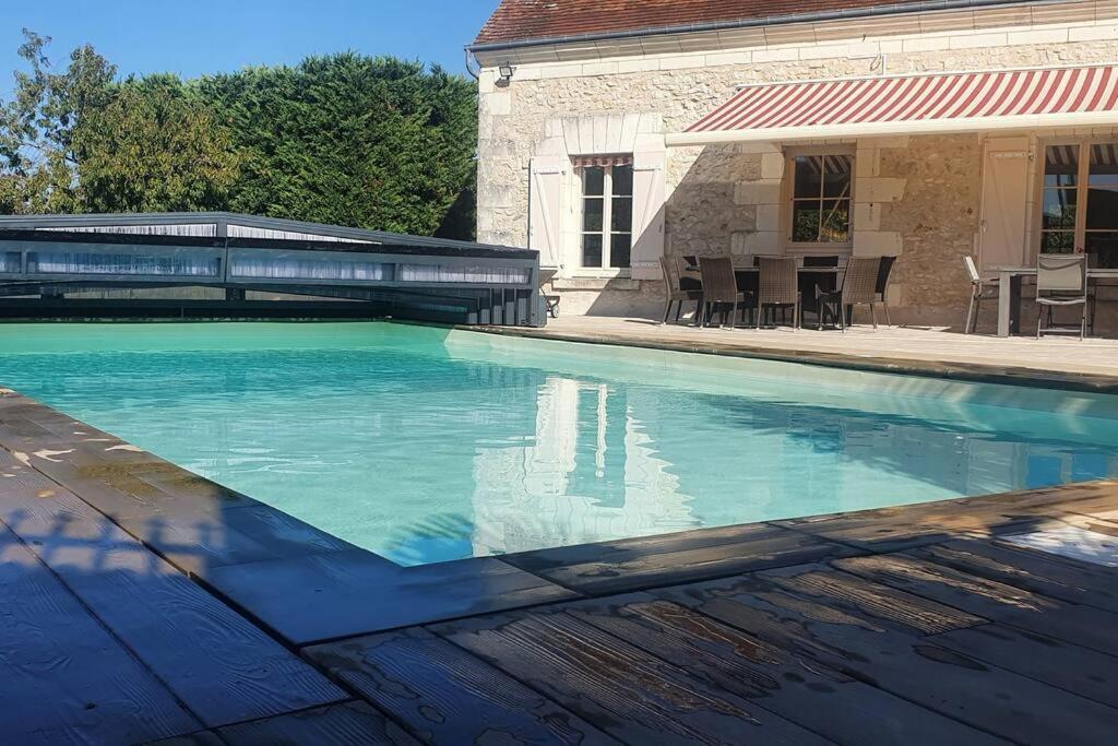 LuzilléLongère avec Piscine Couverte Chauffée privative de Avril à Septembre的一座房子前面的蓝色海水游泳池