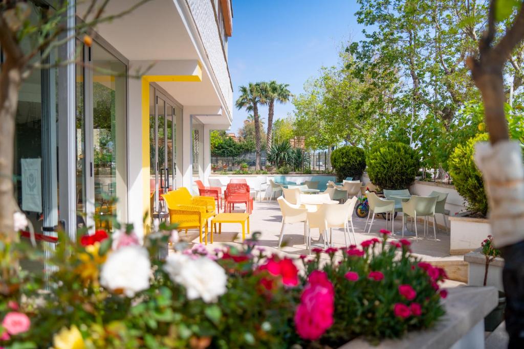 朱利亚诺瓦Hotel Royal的庭院配有桌椅和鲜花